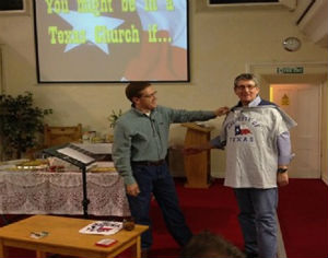 Revd John Singleton is presented with Texan T-shirt
