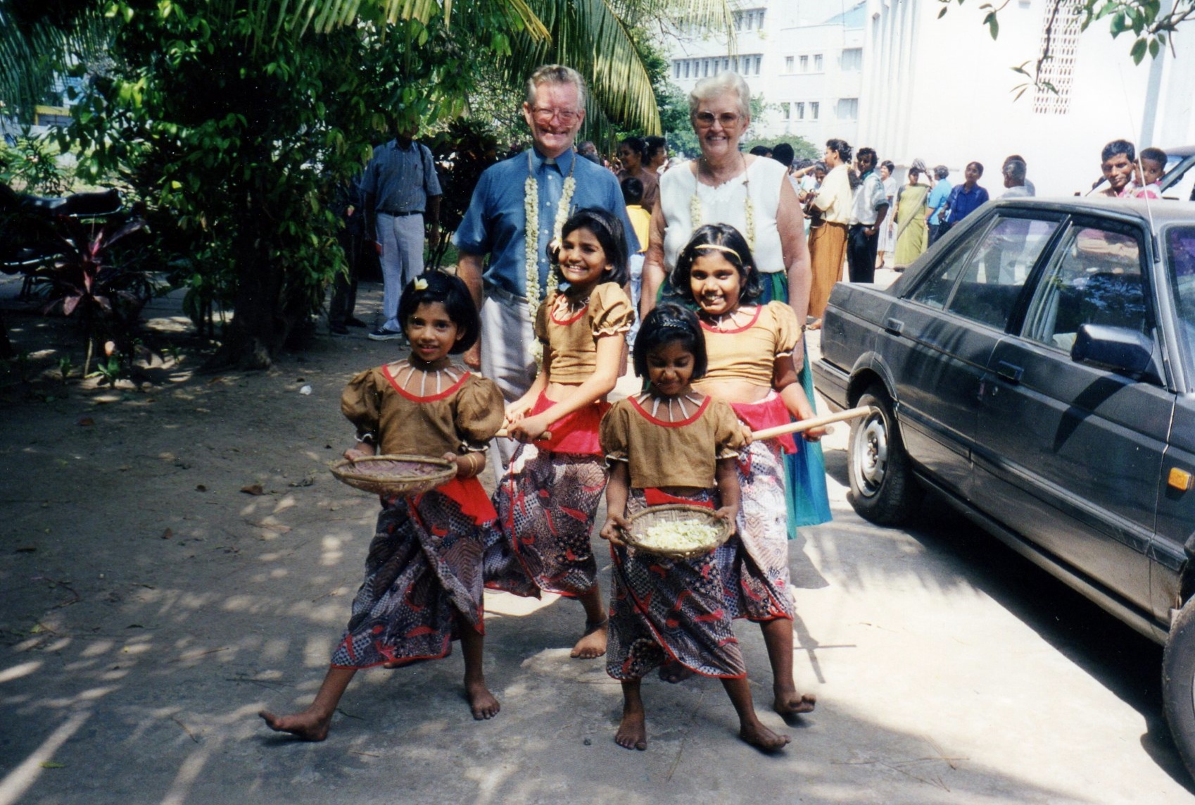 Western couple with four colourfully dressed Sri Lankan children