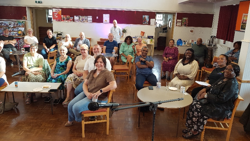 A group of people sat on chairs around tables at Suffolks Baptist Church