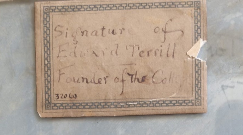 An aged, patterned label inscribed in handwriting reading "Signature of Edward Terrill, Founder of the College"